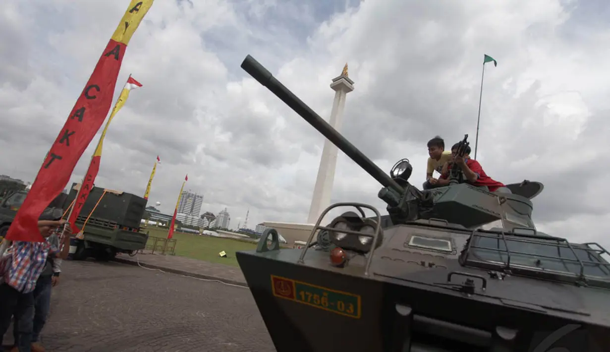 Selain berfoto, sejumlah warga juga antusias menaiki kendaraan tempur TNI AD di Pameran Alutsista di kawasan Monas, Jakarta, Jumat (12/12/2014). (Liputan6.com/Faizal Fanani)