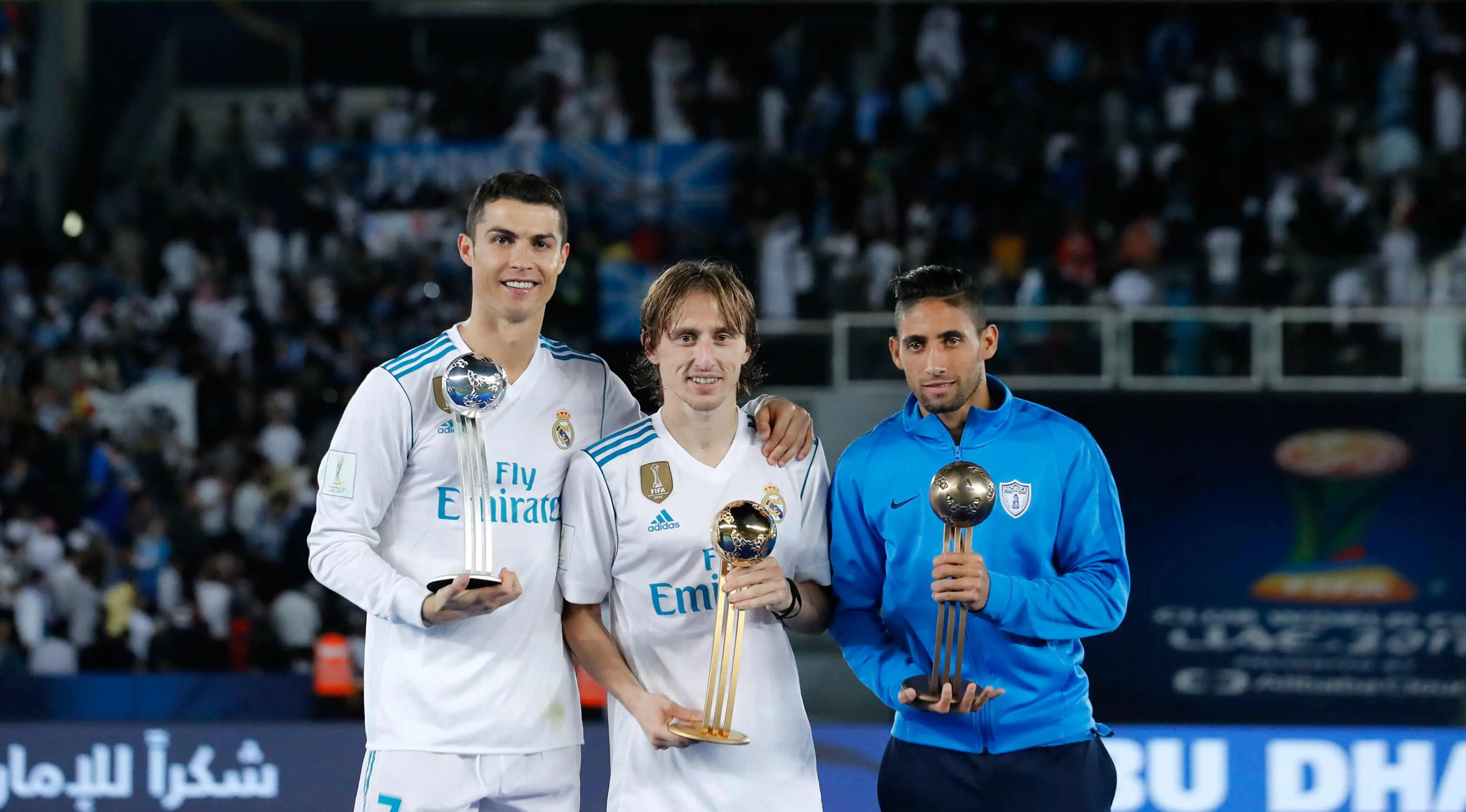 Luka Modric (tengah) berpose dengan Cristiano Ronaldo (kiri) dan Pachuca Jonathan Urretaviscay berpose dengan trofi usai pertandingan pada Piala Dunia Antarklub 2017 distadion Zayed Sports City,Abu Dhabi, Uni Emirat Arab, (16/12). (AP Photo/Hassan Ammar)