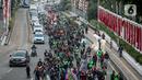 Pengemudi ojek online yang tergabung dalam Koalisi Ojol Nasional melakukan longmarch untuk menggelar aksi di depan Gedung DPR RI, Jakarta, Senin (29/8/2022). Ratusan pengemudi ojek online tersebut menuntut beberapa hal di antaranya payung hukum dan legalitas profesi ojek online serta revisi potongan komisi pendapatan mitra. (Liputan6.com/Faizal Fanani)
