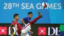 Bek timnas Indonesia U-23, Agung Prasetyo (kiri) membuang bola yang mengarah ke pemain Kamboja di penyisihan Grup A Sea Games 2015 di Stadion Jalan Besar, Singapura, Sabtu (6/6/2015). Indonesia unggul 6-1 atas Kamboja. (Liputan6.com/Helmi Fithriansyah)