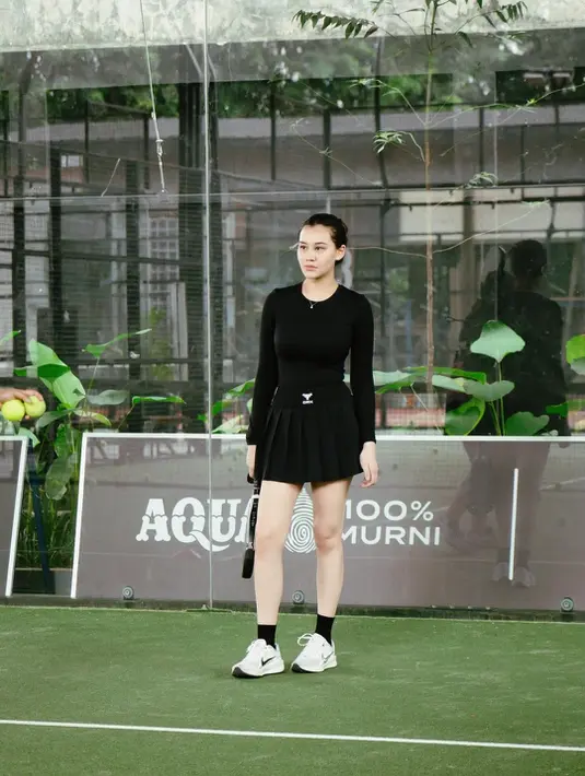 Aaliyah Massaid padukan long sleeve dan rok mini ruffle dari Laica berwarna hitam. Nampak kontras dengan warna kulitnya [@aaliyah.massaid]