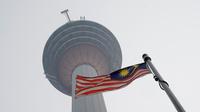 Bendera Malaysia berkibar di bawah Kuala Lumpur Tower saat kabut asap menyelimuti Kuala Lumpur, Malaysia, Rabu (18/9/2019). Badan Meteorologi Klimatologi dan Geofisika (BMKG) mendeteksi sebaran asap akibat kebakaran hutan dan lahan di Sumatra mencapai Malaysia dan Singapura. (AP Photo/Vincent Thian)