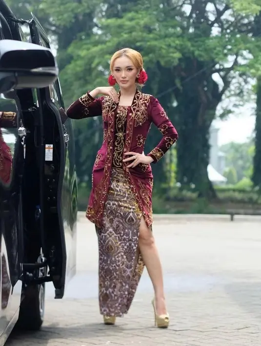 Kebaya warna merah maroon ini memiliki detail suede dan sulaman benang emas. Dibuat fit body, kebaya ini memamerkan tubuh langsing ibu satu anak ini. (Instagram/zaskia_gotix).