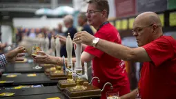 Staf bar melayani penggemar bir selama The Great British Beer Festival di Kensington Olympia di London barat (6/8/2019). Great British Beer Festival tahunan ini diadakan 6-10 Agustus 2019. (AFP Photo/Tolga Akmen)