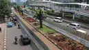 Kendaraan melintas di samping-pohon-pohon terdampak penataan ulang trotoar  di kawasan Sudirman, Jakarta, Jumat (9/3). Proses relokasi pohoN-pohon itu sudah dimulai sejak Selasa (6/3) dan ditarget selesai bulan Maret Ini. (Liputan6.com/Arya Manggala)
