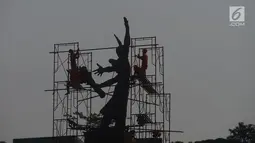 Pekerja memasang rangka besi untuk membersihkan Patung Selamat Datang di Bundaran HI, Jakarta, Sabtu (4/8). Patung Selamat Datang dibersihkan untuk perhelatan Asian Games 2018 yang akan berlangsung pertengahan Agustus bulan ini. (Merdeka.com/Imam Buhori)