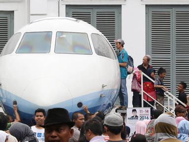 Pengunjung antre untuk masuk ke Pesawat N250 pada Habibie Festival di Museum Nasional, Jakarta, Minggu (14/8). Tingginya antusiasme warga membuat pengunjung harus antre untuk dapat melihat bagian dalam kendaraan tersebut. (Liputan6.com/Immanuel Antonius)