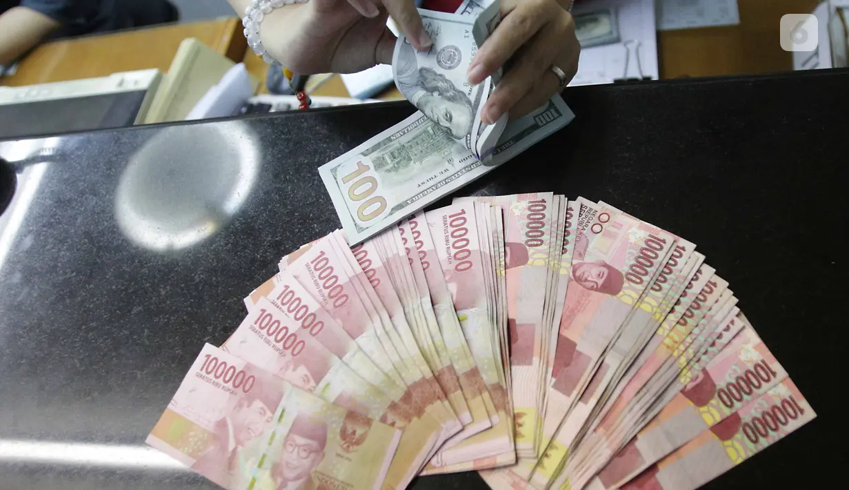Teller menukarkan mata uang dolar ke rupiah di Jakarta, Jumat (2/2). Deputi Gubernur Senior BI Mirza Adityaswara mengatakan, posisi nilai tukar rupiah terhadap dolar Amerika Serikat yang berada di level Rp13.700 hingga Rp13.800.(Liputan6.com/Angga Yuniar)