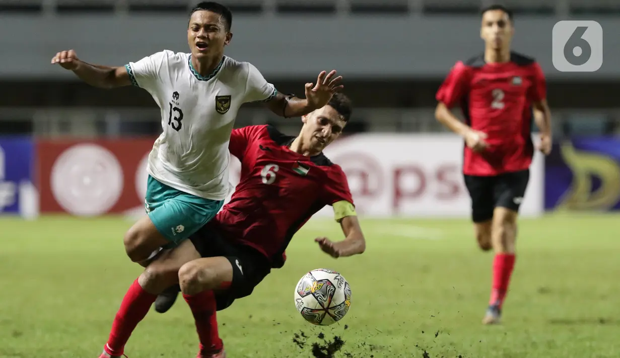 Pemain Timnas U-17 Indonesia, Azzaky Esa Erlangga (kiri) berebut bola dengan Mohammed Manassara (Palestina U-17) pada Kualifikasi Grup B Piala Asia U-17 2023 di Stadion Pakansari, Kab. Bogor, Jawa Barat, Jumat (7/10/2022). Kemenangan atas Palestina memperbesar peluang timnas U-17 Indonesia lolos ke Piala Asia U-17 2023. (Liputan6.com/Helmi Fithriansyah)