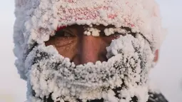Seorang pelari melihat fotografer setelah ikut serta dalam maraton terdingin di Dunia Internasional pada suhu minus 53 derajat di dekat Oymyakon, republik Sakha, juga dikenal sebagai Yakutia, Rusia, pada 22 Januari 2022. Sebanyak 65 pelari bersaing dalam suhu yang sangat rendah. (AP Photo/Ivan Nikif