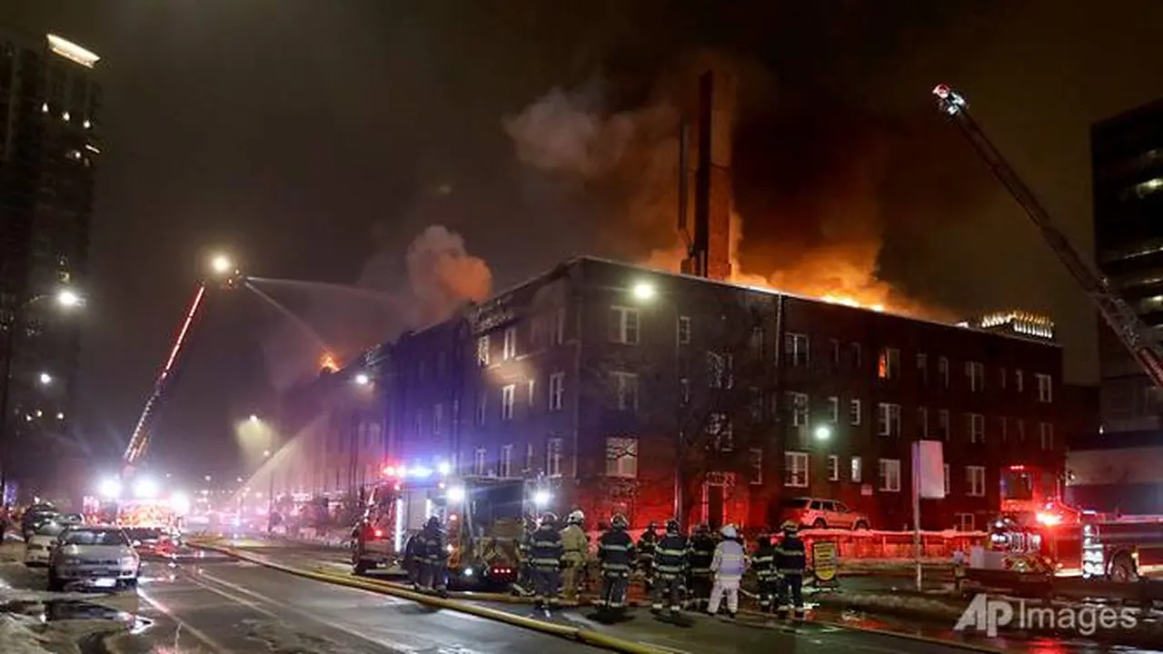 Petugas pemadam kebakaran memadamkan kebakaran empat alarm di apartemen Francis Drake Hotel yang pecah dini hari tanggal 25 Desember 2019, di Minneapolis, Minnesota.