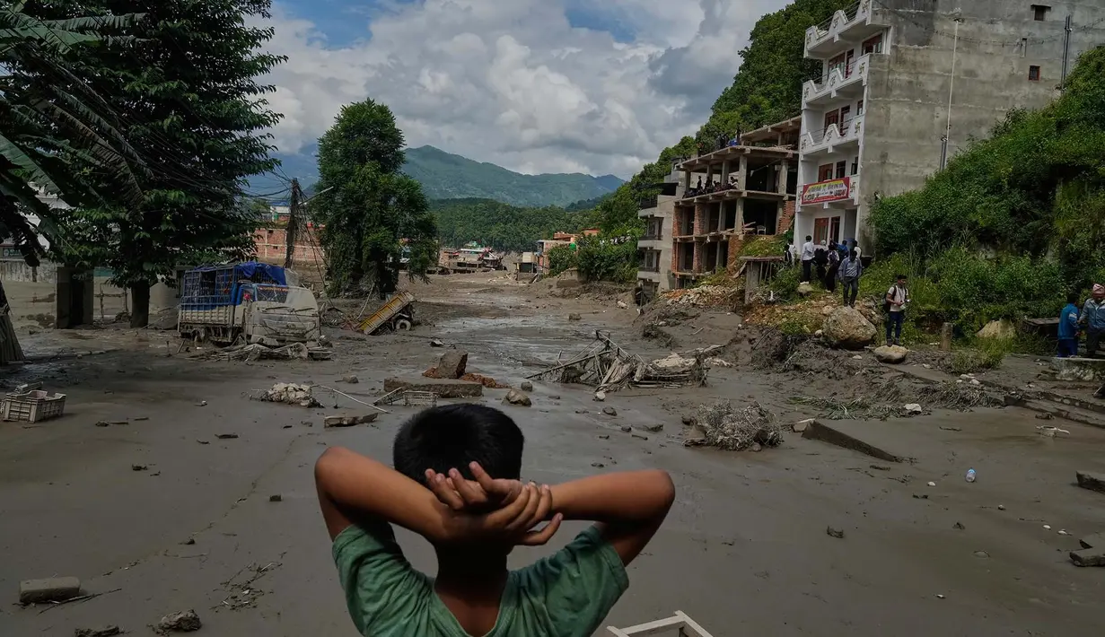 Seorang anak laki-laki melihat kerusakan akibat banjir bandang di sepanjang Sungai Trishuli di distrik Nuwakot, Nepal, Rabu, 26 Agustus 2026. (Foto AP/Niranjan Shrestha)