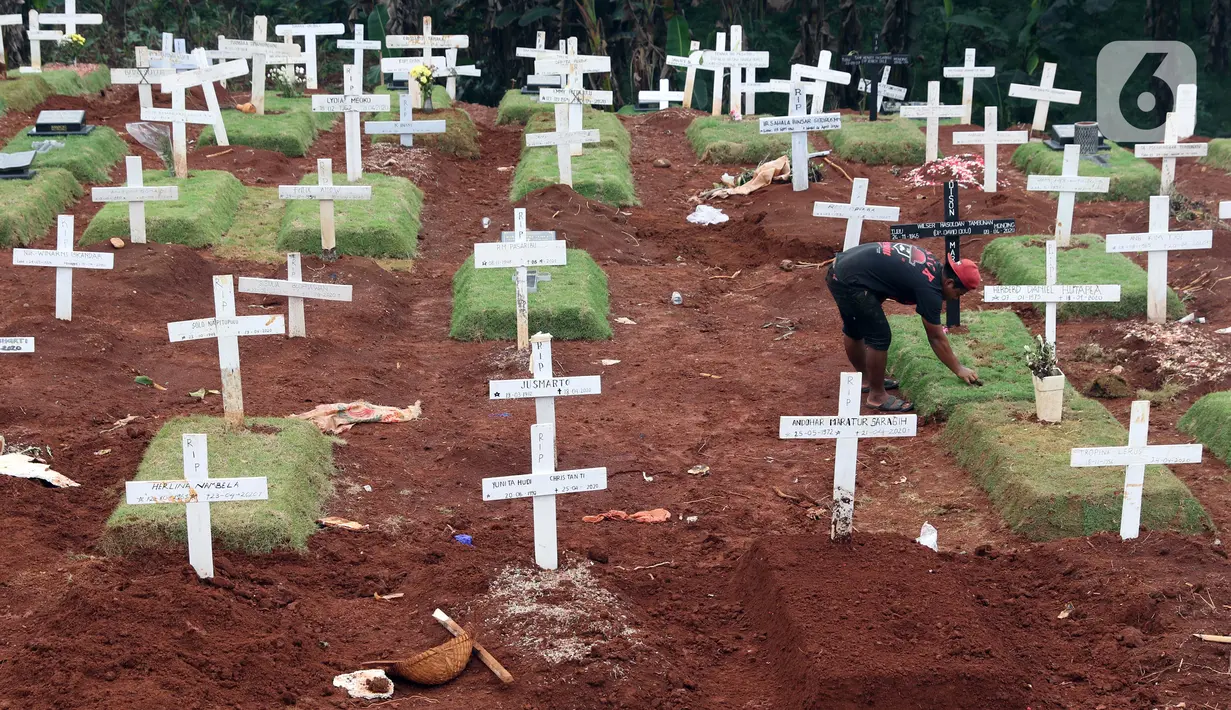 Pekerja sedang melakukan perawatan lokasi pemakaman jenazah yang diduga terinfeksi Covid-19 di TPU Pondok Ranggon, Jakarta, Kamis {30/4/2020). Sejumlah makam terlihat mulai dipasangi rumput dan batu nisan. (Liputan6.com/Helmi Fithriansyah)