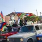 Rakyat Azerbaijan mengibarkan bendera nasional di Ganja, Azerbaijan, Selasa (10/11/2020). Armenia dan Azerbaijan mengumumkan perjanjian damai untuk menghentikan pertempuran atas wilayah Nagorno-Karabakh di Azerbaijan berdasarkan pakta yang ditandatangani dengan Rusia. (AP Photo/Aydin Mammedov)
