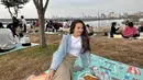 Di tepi Sungai Han, menjadi salah satu tempat yang sangat populer di Korea Selatan untuk menjadi salah satu spot piknik keluarga. Terlihat dalam potret yang diunggah Beby Tsabina tersebut, banyak orang menikmati piknik di tepi sungai. (Liputan6.com/IG/@bebytsabina)