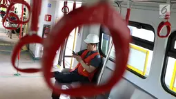 Seorang petugas berada di gerbong kereta Light Rail Transit (LRT) ketika melakukan ujicoba di Kelapa Gading, Jakarta, Kamis (14/6). Kereta LRT diuji coba sejauh 1,1 kilometer dengan kecepatan 80 km per jam. (Liputan6.com/Immanuel Antonius)