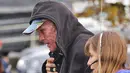 Aktor Hollywood Ryan Reynolds berjalan dengan menutupi wajahnya yang tertutup make up seperti luka terbakar untuk melakukan syuting  "Deadpool". Aktor 39 tahun ini memerankan wajah Wade Wilson dalam filmnya tersebut. (Dailymail)