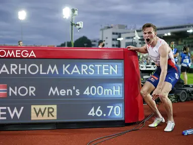 Pelari Norwegia Karsten Warholm melakukan selebrasi di depan papan skor usai memenangkan ajang Diamond League di Oslo, Norwegia, Kamis (1/7/2021). Karsten Warholm memecahkan rekor dunia lari gawang 400 meter putra dengan torehan waktu 46,70 detik. (Fredrik Hagen, NTB via AP)