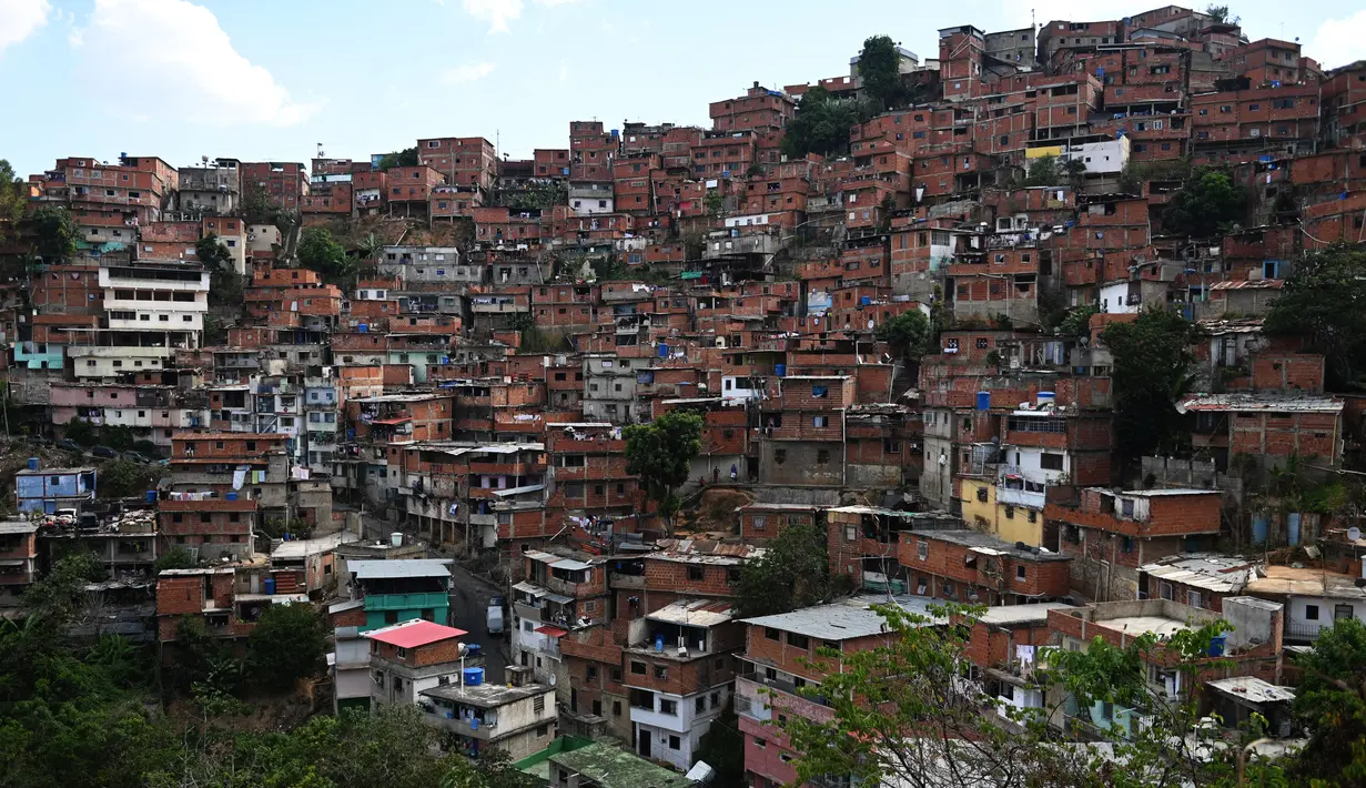 Pemandangan rumah-rumah yang saling berhimpitan di permukiman kumuh Petare di Caracas pada 19 Mei 2019. Petare yang merupakan kawasan kumuh terbesar di Venezuela menjadi rumah bagi lebih dari 500.000 jiwa. (Photo by MARVIN RECINOS / AFP)