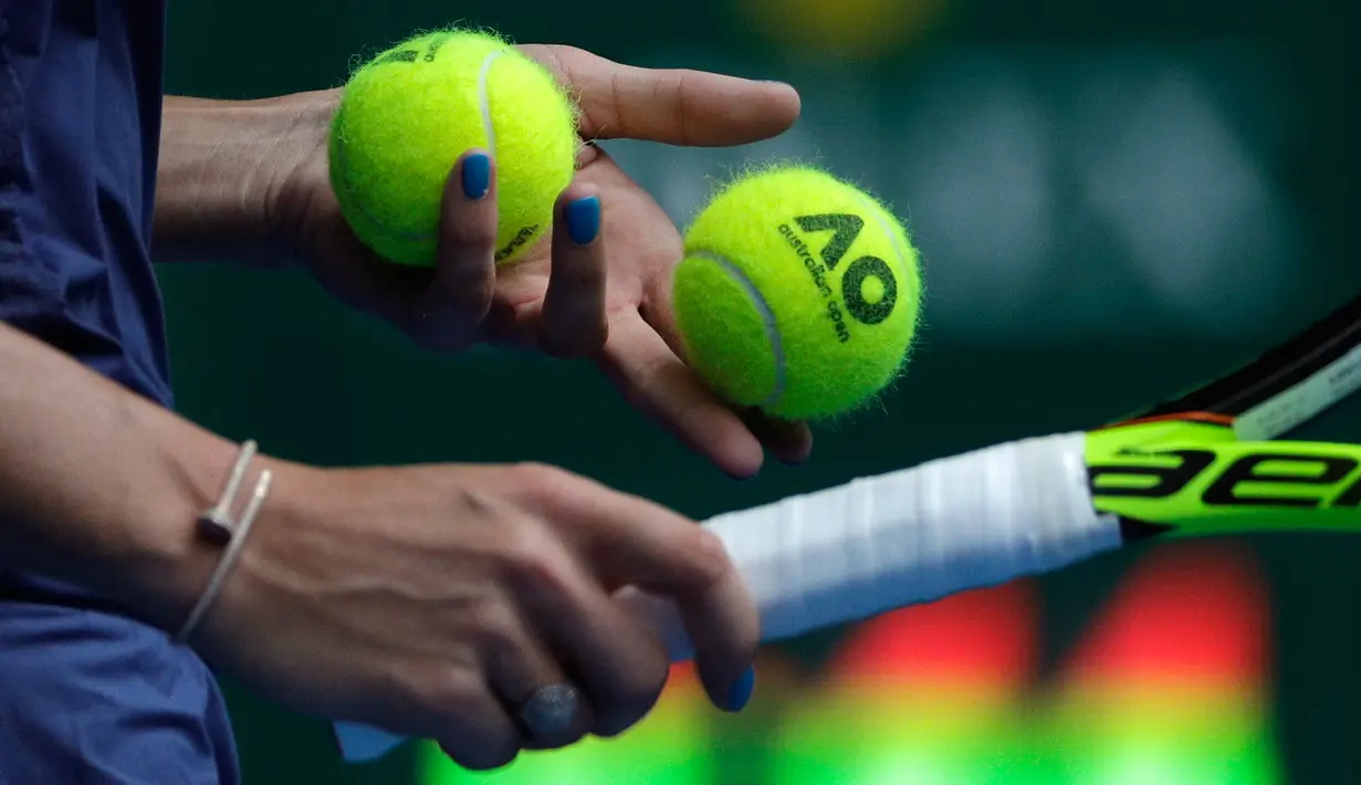 Tangan dengan cat kuku biru milik petenis Denmark, Caroline Wozniacki saat bertanding menghadapi petenis Slovakia Magdalena Rybarikova pada gelaran turnamen tenis Australia Terbuka 2018 di Melbourne, Minggu (21/1).  (AP Photo / Dita Alangkara)