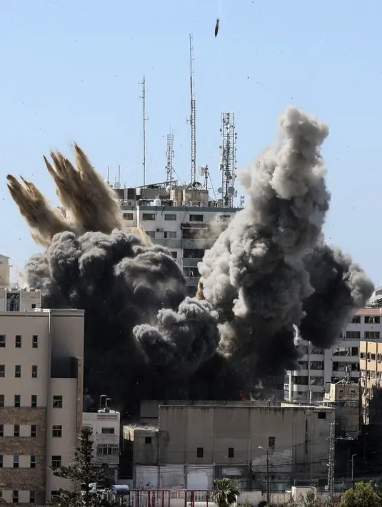 Asap mengepul dari gedung yang menampung berbagai media internasional, termasuk The Associated Press, setelah serangan udara Israel di Kota Gaza, Sabtu (15/5/2021). Gedung tersebut juga menampung Al Jazeera dan sejumlah kantor serta apartemen. (Mahmud Hams /Pool Photo via AP)