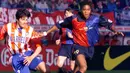 Pemain Barcelona, Patrick Kluivert (kanan) berebut bola dengan pemain Atletico Madrid, Jose Antonio Chamot pada laga lanjutan Liga Spanyol di Madrid, 25 April 1999. Jersey Barcelona musim 1999/2000 terlihat memiliki corak khas Blaugrana, yaitu merah, biru, dan biru tua. Menariknya, terdapat angka tahun 1899 - 1999 yang mengapit logo klub tersebut. (AFP/Eric Cabanis)