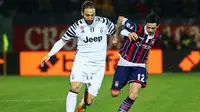 Striker Juventus, Gonzalo Higuain, berusaha melewati pemain Crotone, Adrian Stoian. Dua gol Juventus dicetak oleh Mario Mandzukic dan Gonzalo Higuain, keduanya terjadi pada babak kedua. (EPA/Albano Angilletta)