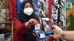 Pengunjung melakukan transaksi menggunakan QR Code BCA mobile pada pameran Adi Wastra Nusantara di Jakarta (11/2/2022). Pada Desember 2021, BCA mencatatkan kredit komersial dan UKM naik 4,8% YoY menjadi Rp195,8 triliun dan terus memperluas penggunaan QRIS. (Liputan6.com/HO/Eko)