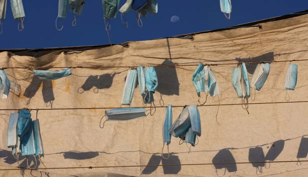 Masker wajah digantung di kapal selama penguncian nasional untuk mengekang penyebaran virus corona, di pelabuhan di kota campuran Arab Yahudi Jaffa, dekat Tel Aviv, Israel, Rabu (7/10/2020). (AP Photo/Oded Balilty)