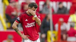 Pemain Manchester United, Bruno Fernandes, menutup wajahnya setelah ditaklukkan Brighton and Hove Albion pada laga Liga Inggris di Stadion Old Trafford, Sabtu (16/9/2023). Setan Merah takluk 1-3 dari Brighton. (AP Photo/Dave Thompson)