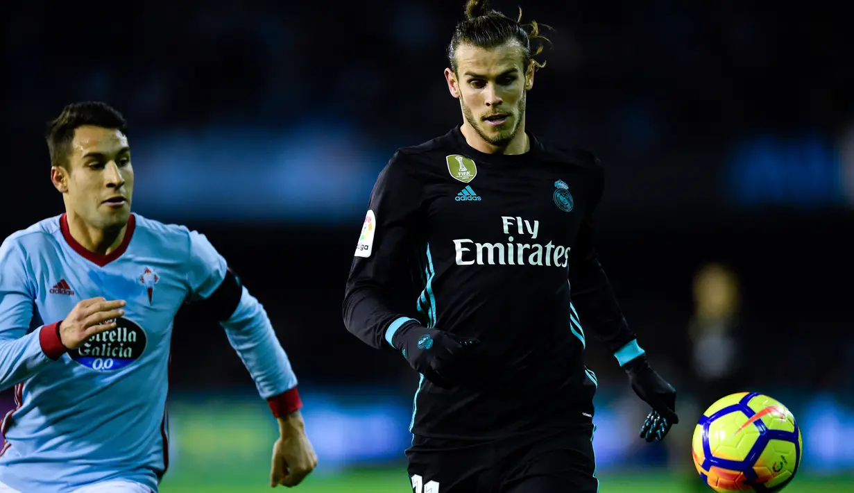 Pemain Real Madrid, Gareth Bale dan bek Celta Vigo, Hugo Mallo berebut bola pada pertandingan pekan ke-18 La Liga kontra Celta Vigo di Estadio de Balaidos, Minggu (7/1). Sempat unggul, Madrid akhirnya harus puas dengan skor akhir 2-2. (MIGUEL RIOPA/AFP)