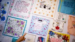 Seniman Amerika, Diana Weymar menunjuk beberapa proyeknya "Tiny Pricks" di toko Lingua Franca, New York City pada 25 Juli 2019. Diana Weymar menyulam komentar-komentar Presiden Donald Trump ke dalam serbet dapur, celemek bayi, hingga pakaian dalam. (EDUARDO MUNOZ ALVAREZ / AFP)