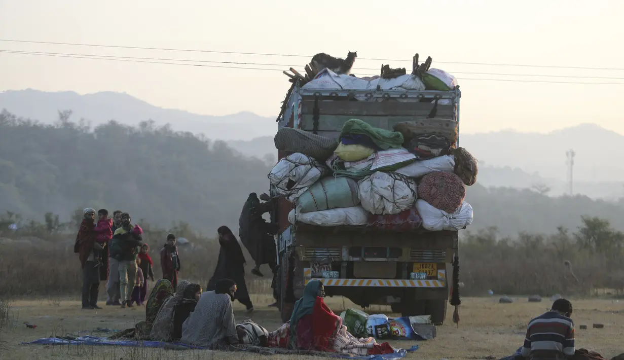 Sebuah keluarga nomaden Gujjar beristirahat di jalan raya Jammu-Srinagar di Nagrota di pinggiran Jammu, India, Selasa (9/11/2021). Anggota suku tersebut pindah dari perbukitan untuk menghindari musim dingin. (AP Photo/Channi Anand)