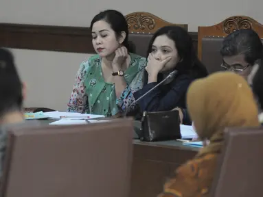 Terdakwa kasus dugaan suap proyek pada Kementerian Pekerjaan Umum dan Perumahan Rakyat, Dessy Ariyanti Edwin (kiri) dan Julia Prasetyarini (tengah) menjalani persidangan di Pengadilan Tipikor, Jakarta, Kamis (21/7). (Liputa6.com/Helmi Afandi)