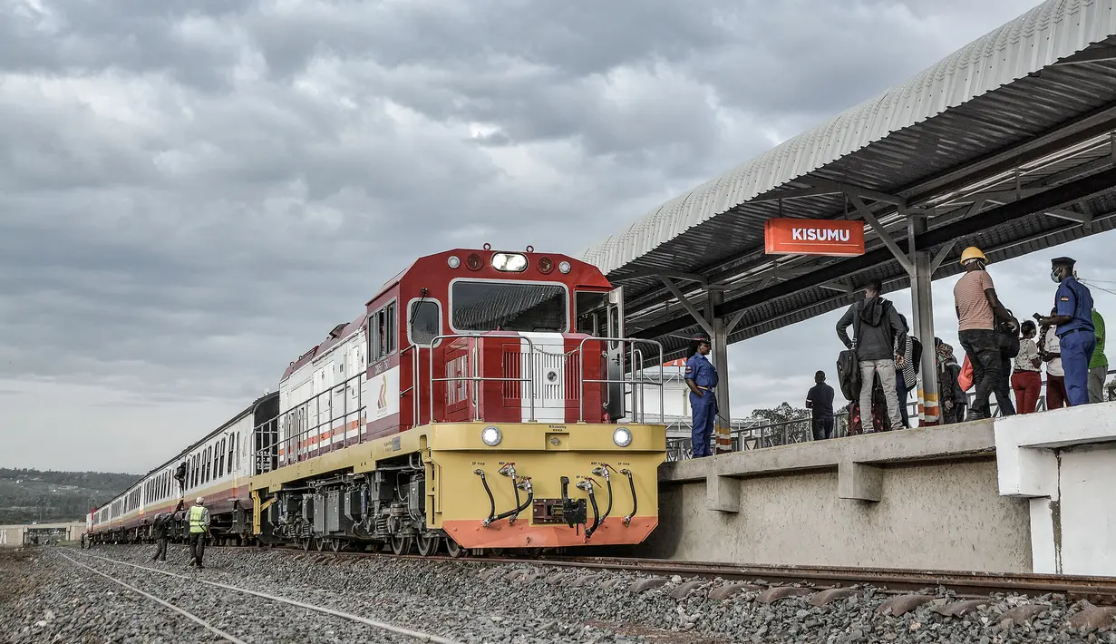 Sebuah kereta tiba di rel tempat penumpang menunggu untuk naik, di stasiun kereta Kisumu, Jumat (17/12/2021). Kereta api Kenya melanjutkan layanan komuter antara Nairobi dan Kisumu setelah tidak beroperasi selama lebih dari 10 tahun. (Brian ONGORO/AFP)