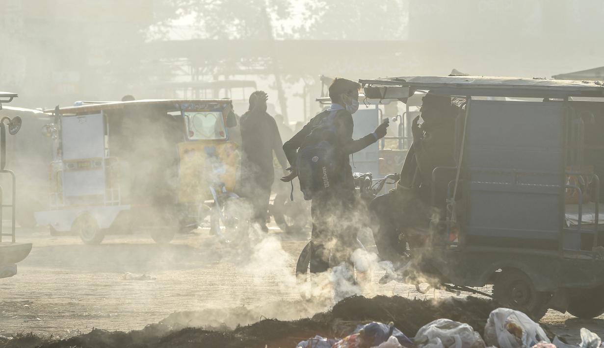 Pengemudi becak menunggu penumpang di jalan di tengah kondisi kabut asap di Lahore, Pakistan (23/11/2021). Kondisi kabut asap yang memburuk membuat Lembaga pendidikan, kantor swasta tutup selama tiga hari seminggu di Lahore. (AFP/Arif Ali)
