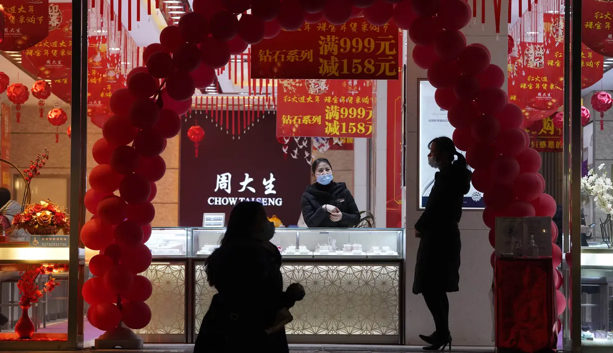 Pekerja yang mengenakan masker menunggu pelanggan di toko perhiasan di Wuhan di provinsi Hubei, China, Jumat (15/1/2021). Selain masker, orang-orang menjalani kehidupan sehari-hari mereka seperti sebelumnya di Wuhan, tempat pertama kali virus corona COVID-19 terdeteksi. (AP Photo/Ng Han Guan)