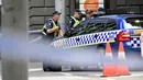 Petugas kepolisian memblokade lokasi dimana sebuah mobil menghantam para pejalan kaki di pusat kota Melbourne, Australia, Jumat (20/1). Seorang pria diduga sengaja menabrakkan mobilnya ke arah pejalan kaki di Jalan Bourke. (AP Photo/Andrew Brownbill)