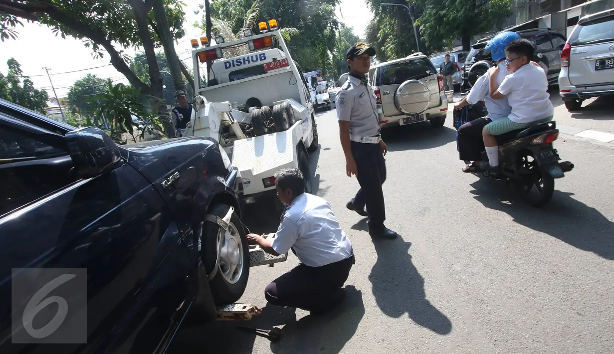Petugas Dishub memasang alat derek ke kendaraan yang parkir liar di kawasan Pasar Baru, Jakarta, Kamis (7/1). Pemprov DKI berencana menaikan denda Rp 3 juta per hari terhadap kendaraan yang terjaring parkir liar. (Liputan6.com/Immanuel Antonius)