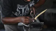 Seorang pandai besi membuat keris tradisional yang dikenal sebagai 'rencong' di sebuah bengkel di Sibreh, provinsi Aceh (5/10/2021). Rencong merupakan senjata khas Suku Aceh. (AFP/Chaideer Mahyuddin)