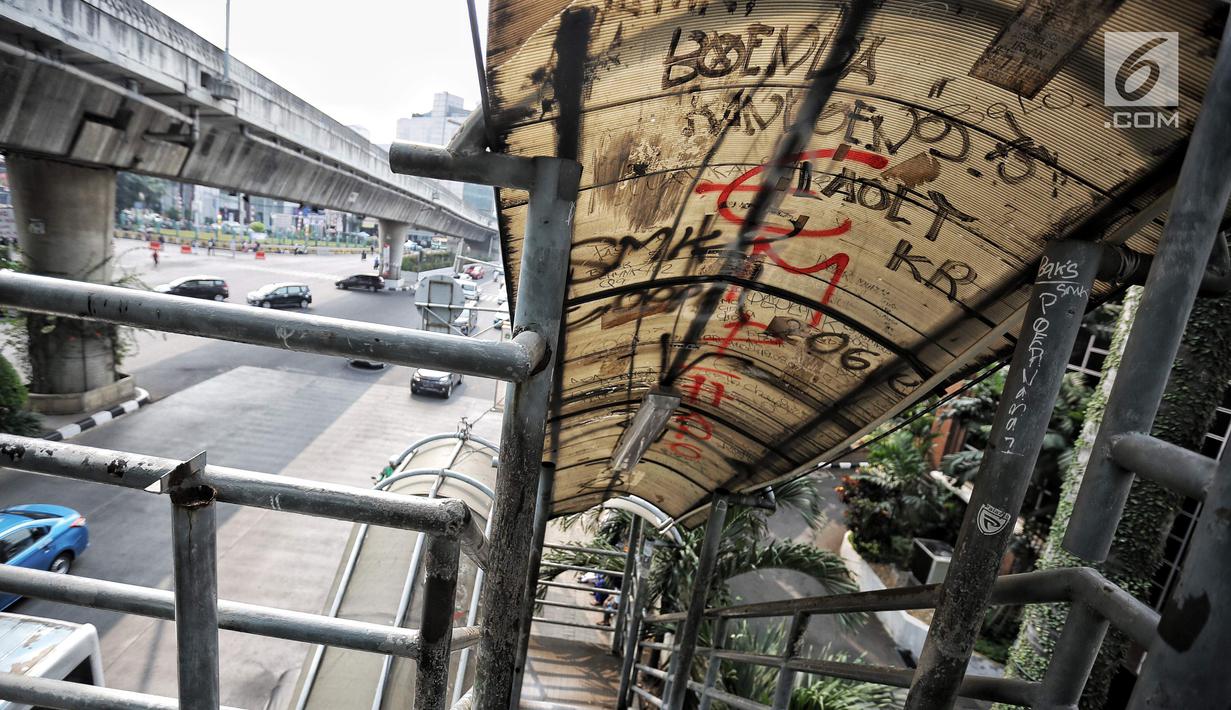 Coret-coretan menghiasi atap Jembatan penyeberangan orang (JPO) di Jalan Iskandarsyah Raya, Blok M, Jakarta, Kamis (23/8). Akibat kondisi JPO yang tidak layak itu banyak pejalan kaki memilih menyeberang di ruas jalan. (Liputan6.com/Faizal Fanani)