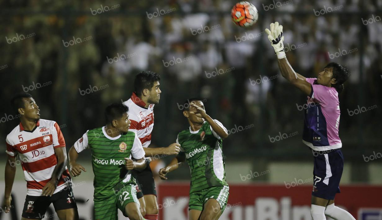 Kiper Madura United, Erry Prasetyo (kanan), mengamankan bola serangan PS TNI dalam laga Torabika Soccer Championship presented by IM3 Ooredoo di Stadion Siliwangi, Bandung, Minggu (1/5/2016). (Bola.com/Vitalis Yogi Trisna)