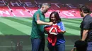 Legenda Manchester United, Ryan Giggs membubuhkan tanda tangannya di atas jersey seorang fans saat sesi meet and greet dalam acara peluncuran kartu kredit Maybank yang berkolaborasi dengan Manchester United di Jakarta Convention Center (JCC), Senayan, Jakarta, Sabtu (18/5/2024). (Bola.com/M Iqbal Ichsan)