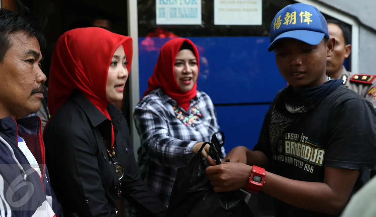 Istri Walikota Bandung Ridwan Kamil, Atalia Praratya (kedua kiri) membagikan makanan kepada pendukung Persebaya Surabaya di GOR Padjajaran, Bandung, Sabtu (7/1). Tiba di Bandung, ratusan bonek berkumpul di GOR Padjajaran. (Liputan6.com/Helmi Fithriansyah)