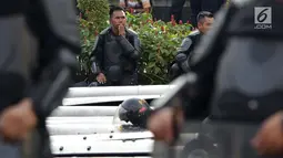Anggota kepolisian dari satuan Brimob beristirahat saat menjaga aksi unjuk rasa yang dilakukan Gerakan Nasional Kedaulatan Rakyat di depan Gedung Bawaslu, Jakarta, Selasa (21/5/2019). Ribuan aparat keamanan gabungan diterjunkan untuk mengamankan jalannya aksi. (Liputan6.com/Helmi Fithriansyah)