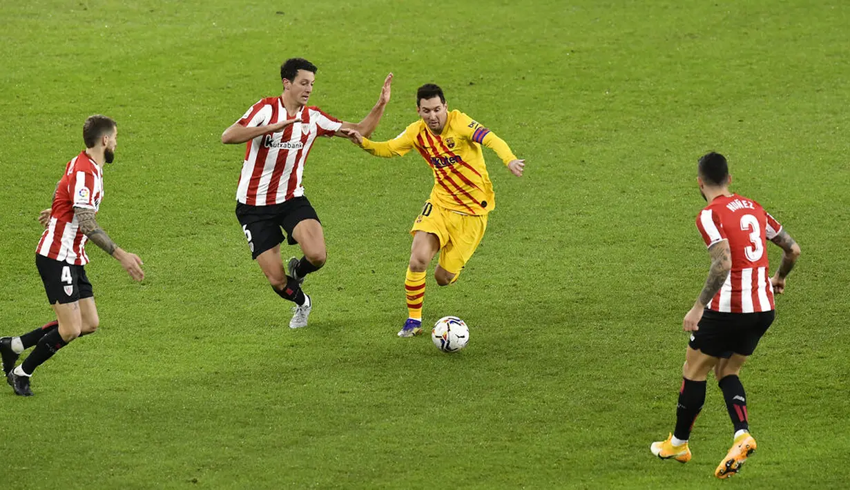 Pemain Barcelona Lionel Messi (kedua kanan) menggiring bola melewati tiga pemain Athletic Bilbao pada pertandingan Liga Spanyol di Stadion San Mames, Bilbao, Spanyol, Rabu (6/1/2021). Barcelona menang 3-2 dengan dua gol dari Lionel Messi. (AP Photo/Alvaro Barrientos)