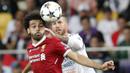 Striker Liverpool, Mohamed Salah, berebut bola dengan bek Real Madrid, Sergio Ramos, pada laga final Liga Champions di Stadion NSC Olimpiyskiy, Kiev, Minggu (27/5/2018). Salah mengalami cedera bahu usai dilanggar Ramos. (AP/Efrem Lukatsky)