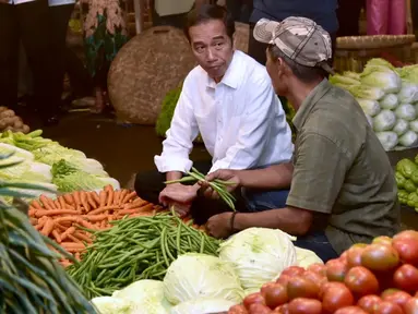 Presiden Joko Widodo berbincang dengan pedagang ketika memantau kebutuhan bahan pokok di Pasar Bogor, Jalan Roda, Kota Bogor, Selasa (30/10). Jokowi ingin memastikan langsung harga bahan kebutuhan pokok di pasar. (Liputan6.com/HO/Biro Pers Setpres)