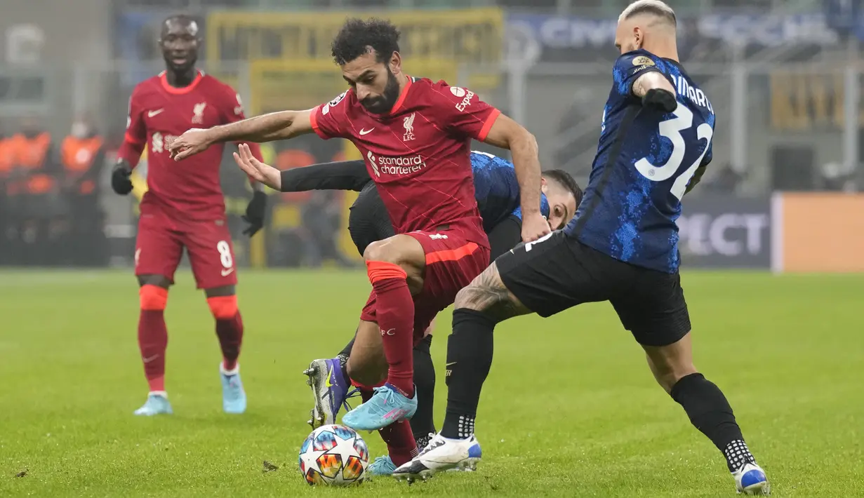 Penyerang Liverpool Mohamed Salah berebut bola dengan pemain Inter Milan Roberto Gagliardini dan Federico Dimarco pada leg pertama babak 16 besar Liga Champions di Stadion Giuseppe Meazza, Kamis dini hari WIB (17/2/2022). Melawat ke markas Inter Milan, Liverpool menang 2-0 (AP Photo/Antonio Calanni)