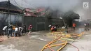 Petugas pemadam kebakaran bersana warga mencoba memadamkan api yang membakar pemukiman padat penduduk di kawasan Manggarai, Jakarta, Rabu (10/7/2019). Belum diketahui pasti penyebab api membakar pemukiman warga tersebut. (Kapanlagi.com/Budy Santoso)